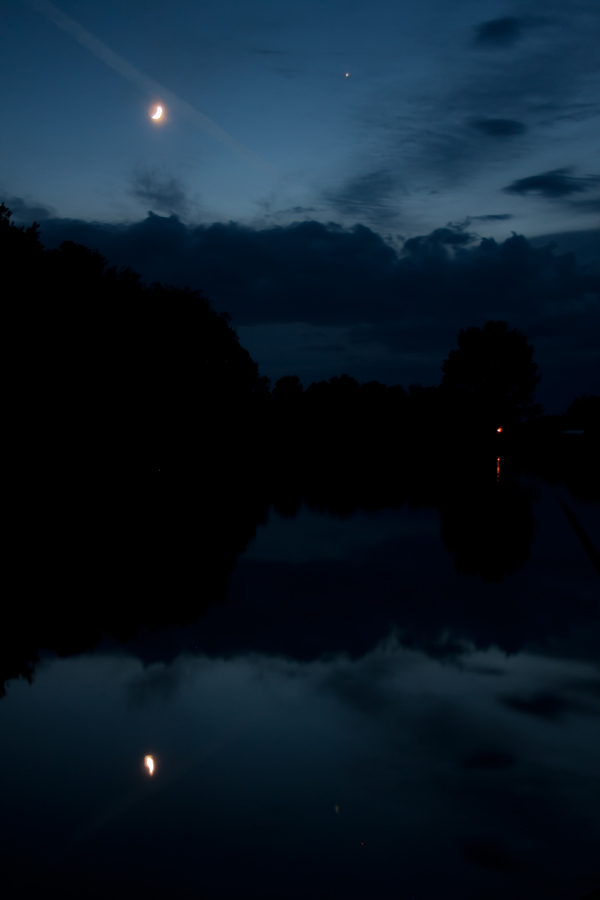 A Hold és a Jupiter fénye csillan meg a Derecskei víztározó víztükrén. Kiss Csongor felvétele 2014. június 2-án készült, az esti szürkületben.